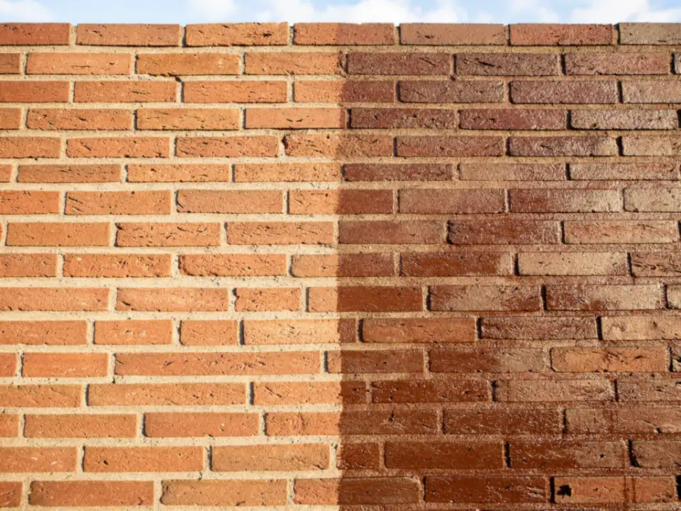 Bakstenen muur waarvan de rechterhelft iets donkerder is van het pas aangebrachte middel