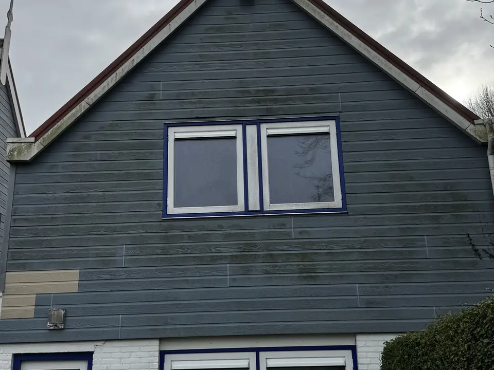 Houten gevel en boeidelen met groene aanslag